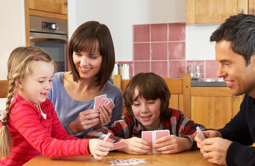 Familie spielt ein Kartenspiel.