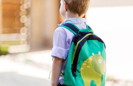 Junge mit grünem Kinderrucksack.