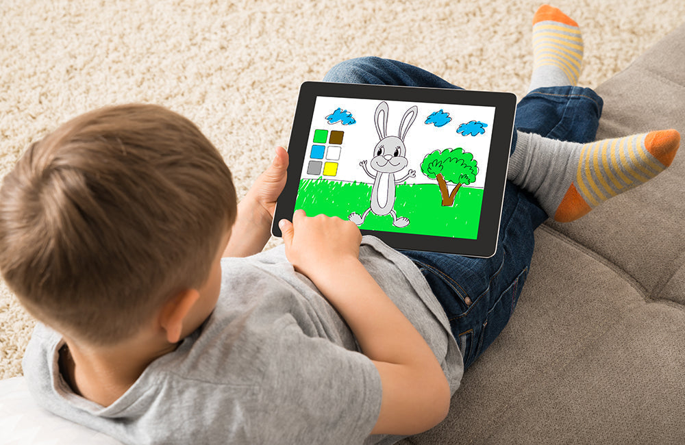 Ein kleines Kind spielt ein Spiel auf einem digitalem Tablet.