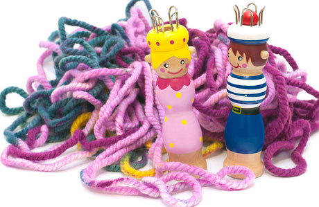 Zwei Stickliesel mit Wolle im Hintergrund.